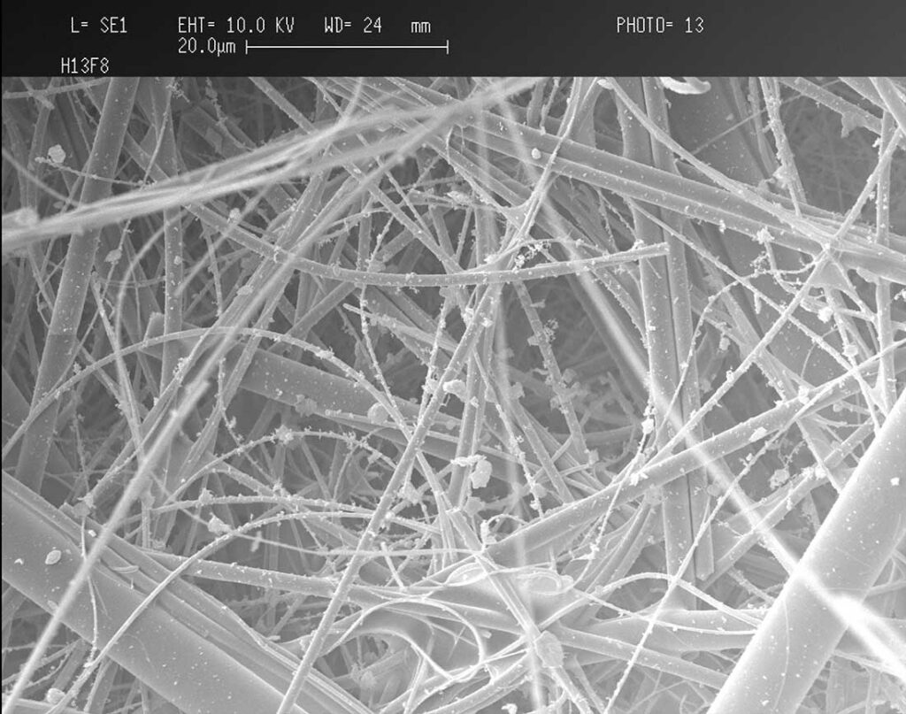 Figure 1: Scanning electro microscopic image illustrating the capture of fine particle on HEPA filter media (H13-EN1882). Photo courtesy of Dr. Iyad Al-Attar